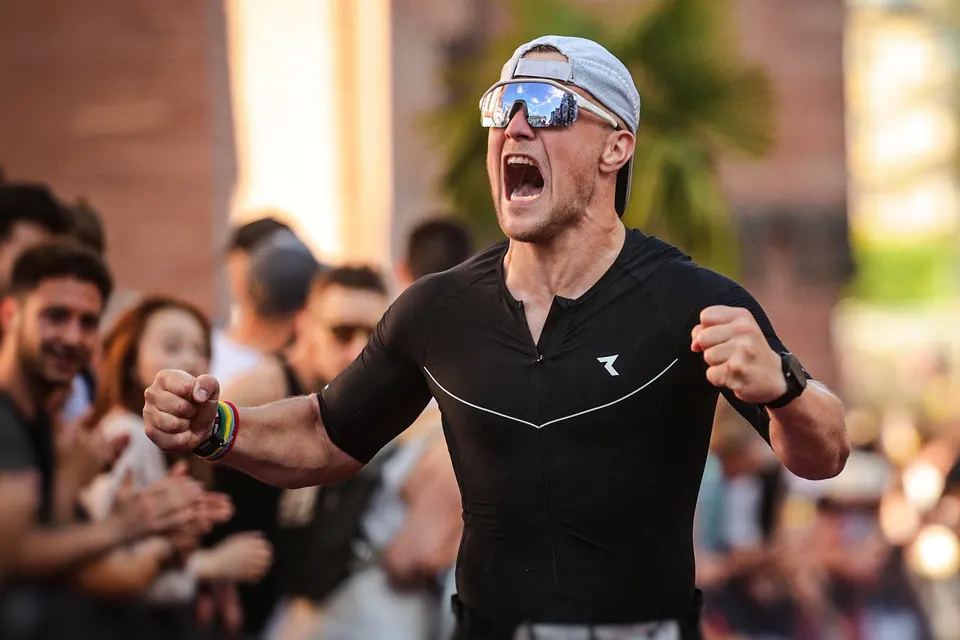 Triathlet jubelt im Ziel vor Zuschauern, Szene aus „Road to Ironman“