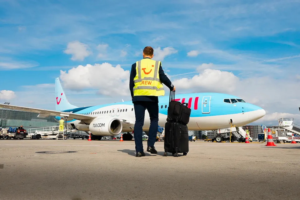 Mitarbeiter in Warnweste vor einem TUI-Flugzeug auf dem Vorfeld