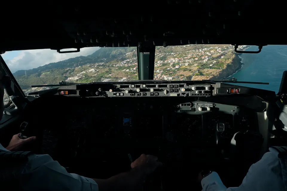 Blick aus dem Cockpit eines Flugzeugs über eine Küstenlandschaft