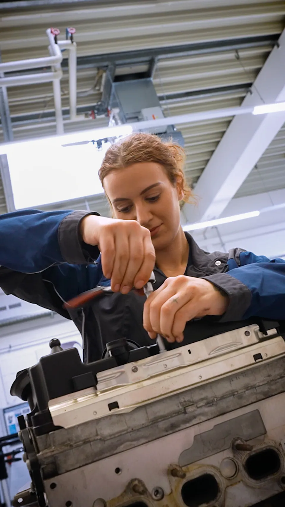 Mitarbeiterin arbeitet an einem Motorblock, Recruiting-Clip für die HIL GmbH