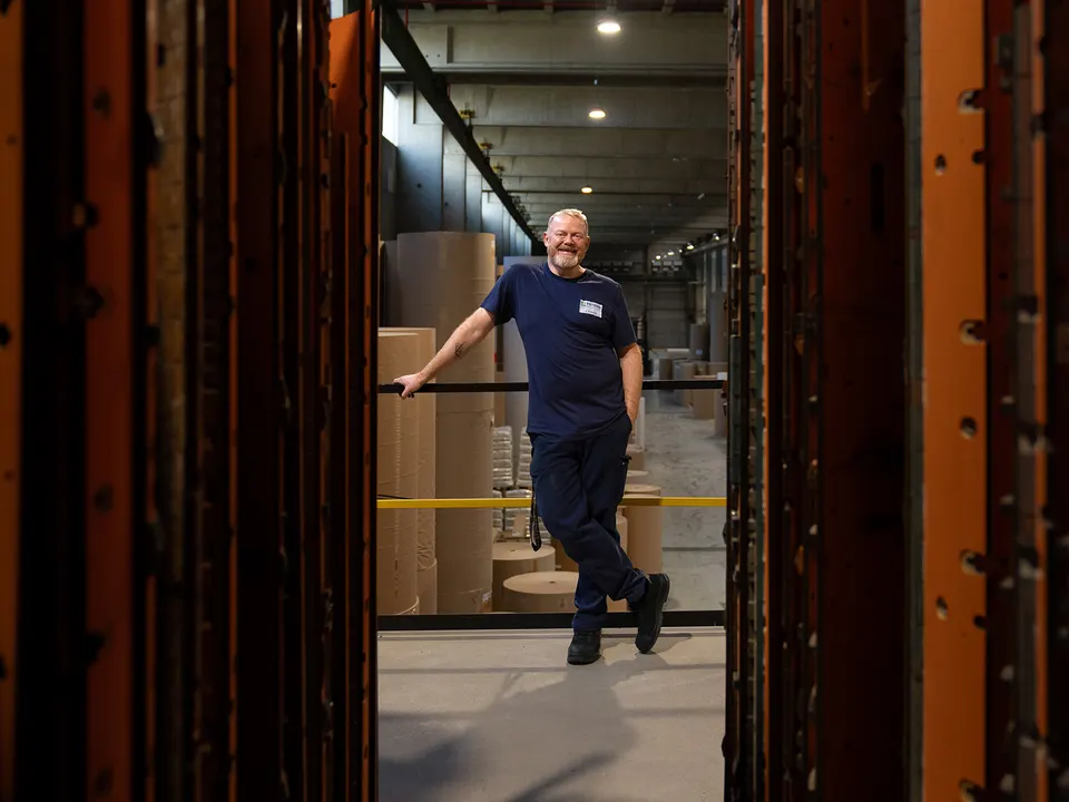 Mitarbeiter lehnt im Gang eines Lagers, Employer-Branding-Fotoshooting