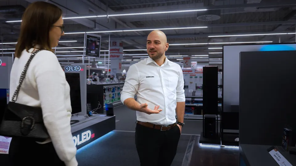 Mitarbeiter berät eine Kundin im Elektronikmarkt