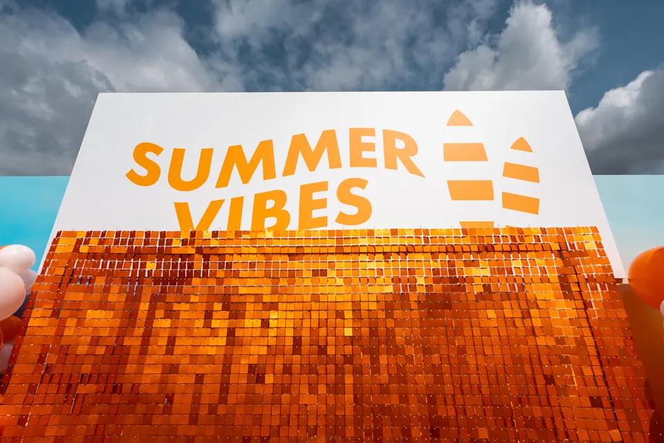 Schild „Summer Vibes“ vor blauem Himmel bei einem Sommerevent