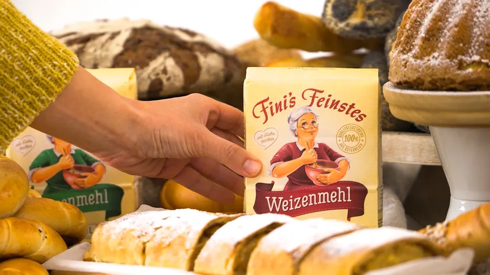 Unternehmensfilm GoodMills Group: Hand hält eine Mehlpackung vor frischen Backwaren