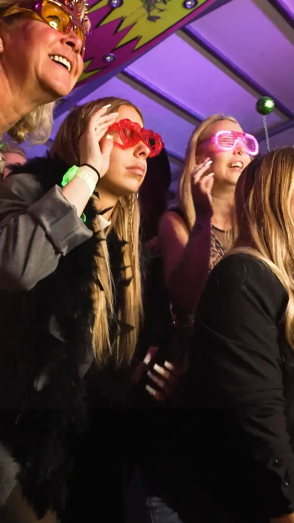 Feiernde Gäste mit Leuchtbrillen bei einem Firmenevent