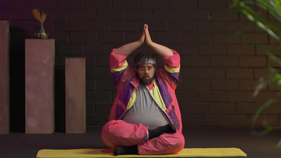 Mann im Retro-Trainingsanzug meditiert auf einer Yogamatte, Werbeclip für Mindfactory